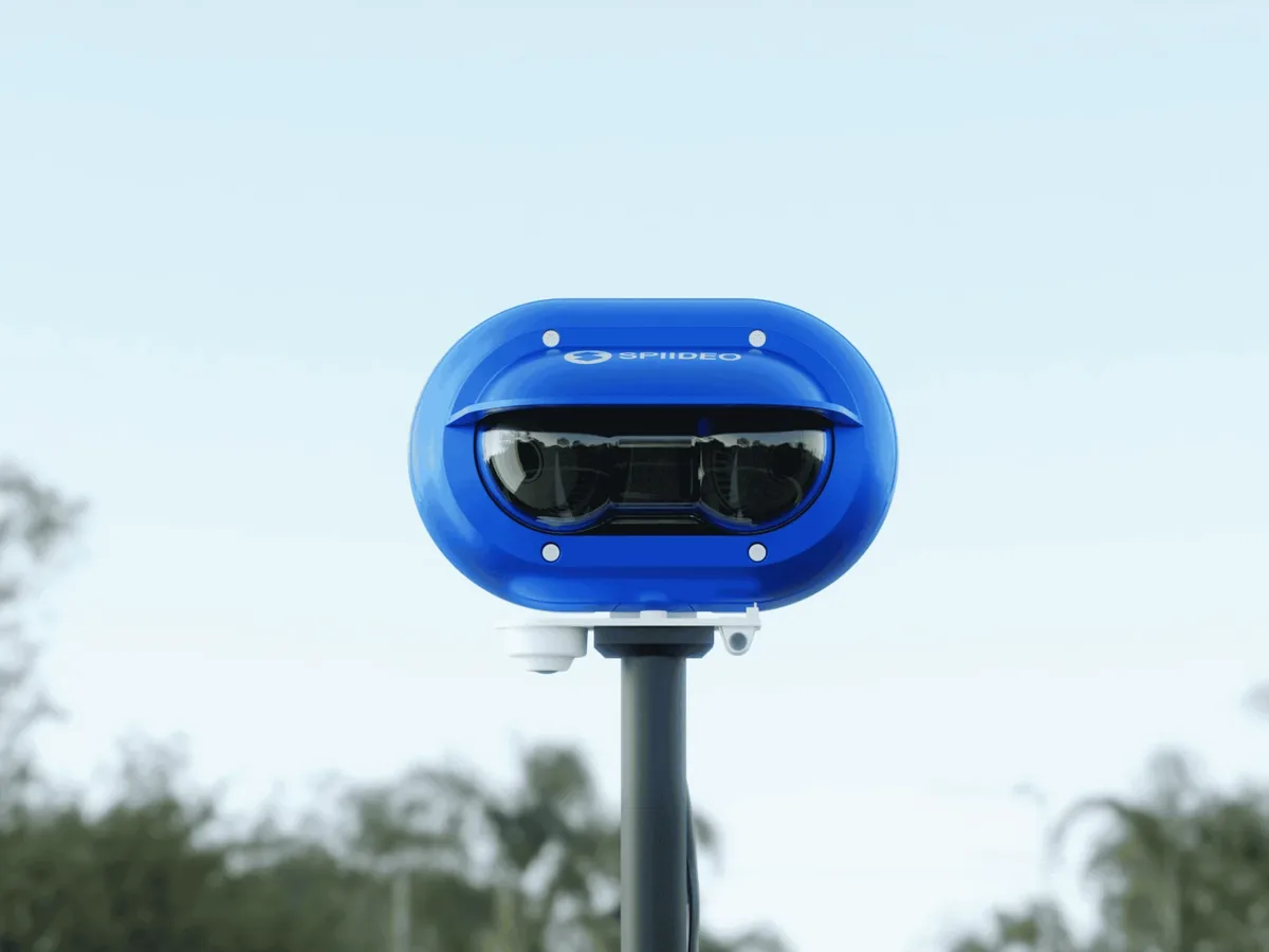 Spiideo camera, a blue oval housing with a wide multi-lens window, mounted on a pole outdoors